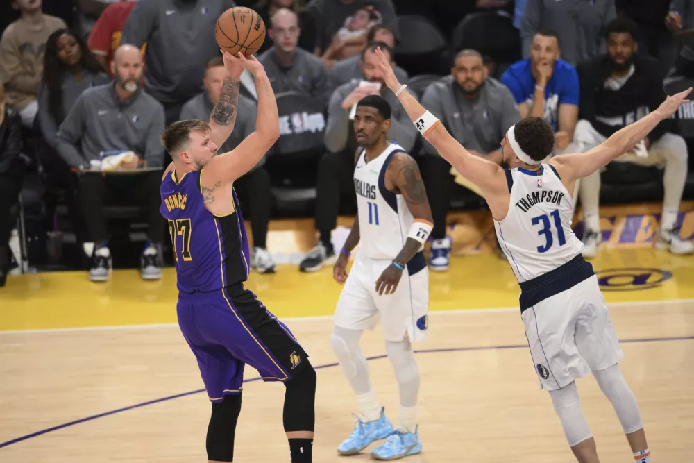 Los Angeles Lakers guard Luka Doncic (77) shoots over Dallas Mavericks guard Klay Thompson (31) during the second half of an NBA basketball game Tuesday, Feb. 25, 2025, in Los Angeles. (AP Photo/Kyusung Gong)