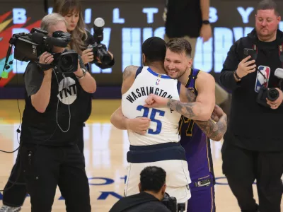 Los Angeles Lakers guard Luka Doncic, center right, greets Dallas Mavericks forward P.J. Washington (25) before an NBA basketball game Tuesday, Feb. 25, 2025, in Los Angeles. (AP Photo/Kyusung Gong)