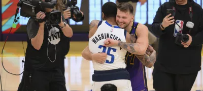 Los Angeles Lakers guard Luka Doncic, center right, greets Dallas Mavericks forward P.J. Washington (25) before an NBA basketball game Tuesday, Feb. 25, 2025, in Los Angeles. (AP Photo/Kyusung Gong)