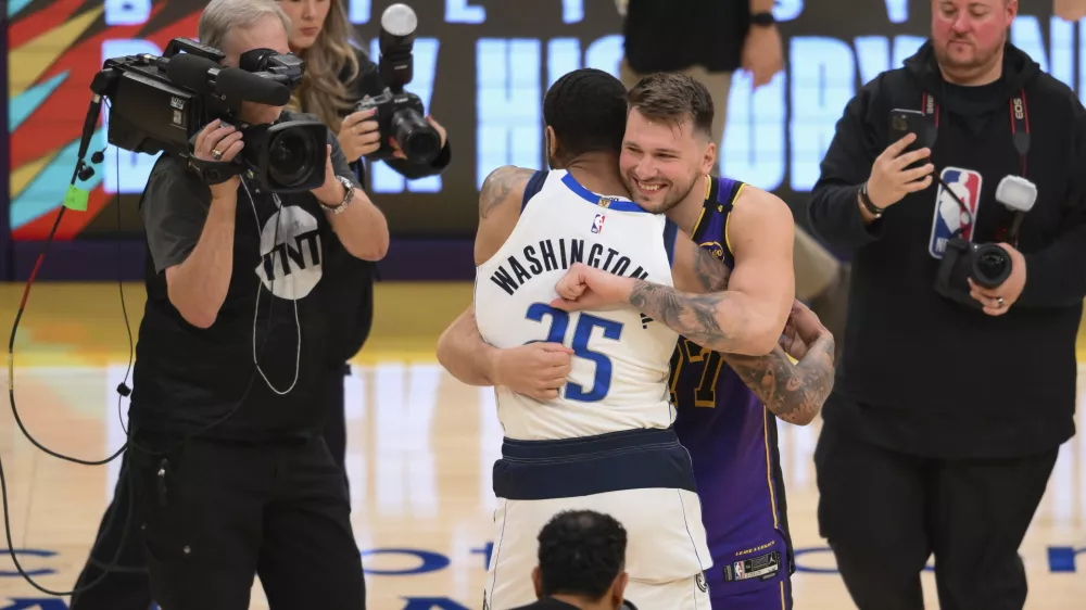 Los Angeles Lakers guard Luka Doncic, center right, greets Dallas Mavericks forward P.J. Washington (25) before an NBA basketball game Tuesday, Feb. 25, 2025, in Los Angeles. (AP Photo/Kyusung Gong)