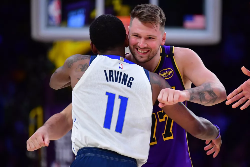 Feb 25, 2025; Los Angeles, California, USA; Los Angeles Lakers guard Luka Doncic (77) reacts with Dallas Mavericks guard Kyrie Irving (11) during the first quarter at Crypto.com Arena. Mandatory Credit: Gary A. Vasquez-Imagn Images