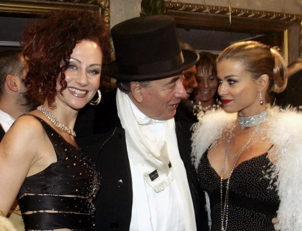 Austrian building tycoon Richard Lugner (C), his wife Christine (L) and U.S. actress Carmen Electra pose for photographers at the beginning of the 50th Opera Ball in Vienna February 23, 2006. Held each year in the State Opera, the prestigious social event attracts guests from around the world. REUTERS/Ronald Zak/Pool