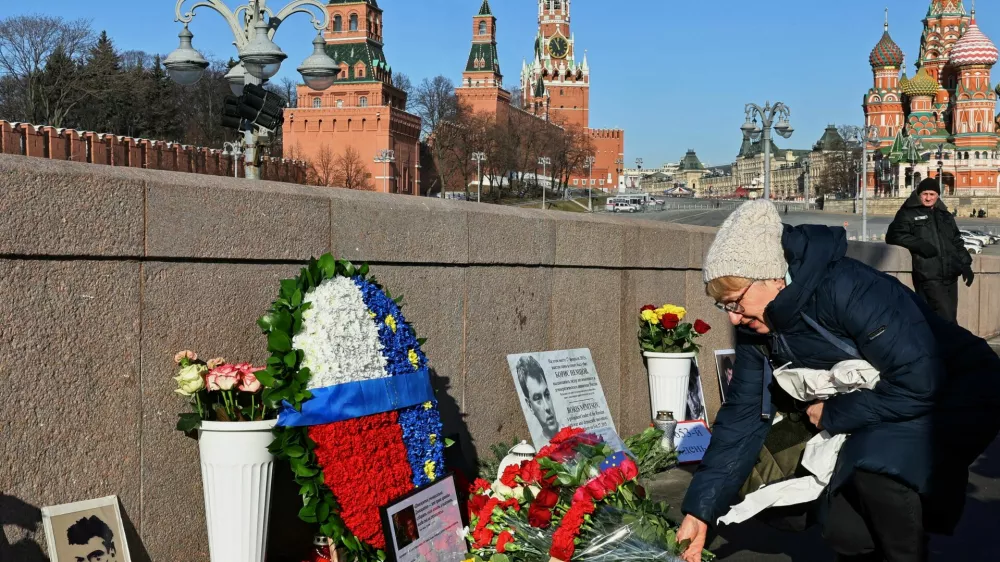 A woman lays flowers in memory of Russian opposition politician Boris Nemtsov at the site of his assassination on the 10th anniversary of Nemtsov's death, in Moscow, Russia February 27, 2025. REUTERS/Evgenia Novozhenina