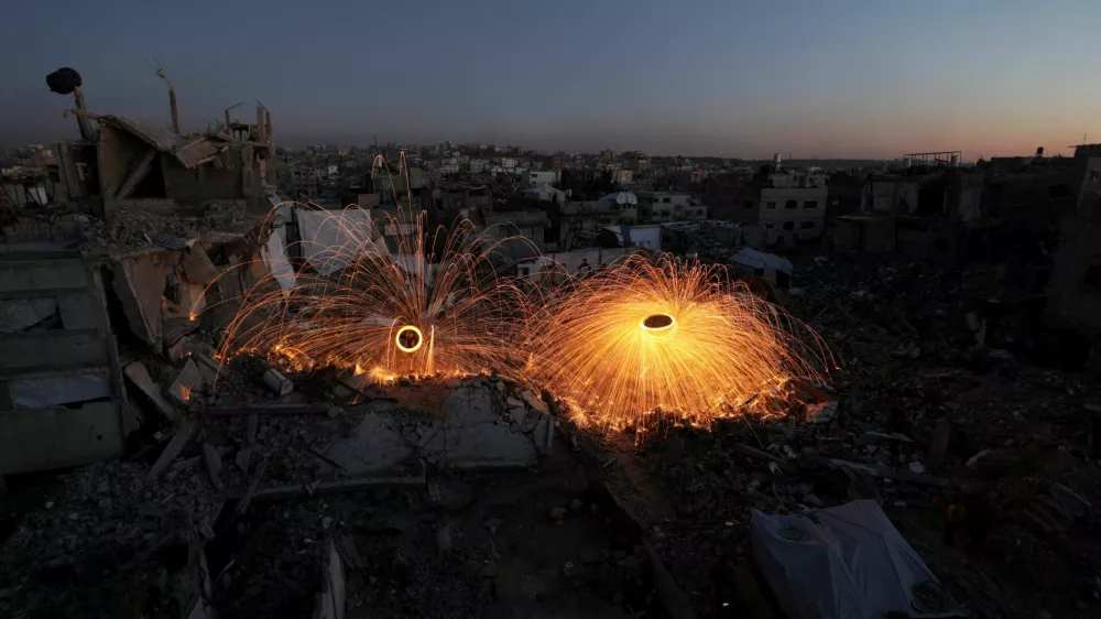 Palestinians spin steel wool sparklers amid the rubble of buildings, ahead of the holy fasting month of Ramadan, amid a ceasefire between Israel and Hamas, at Jabalia refugee camp, northern Gaza Strip, February 28, 2025. REUTERS/Mahmoud Issa   TPX IMAGES OF THE DAY