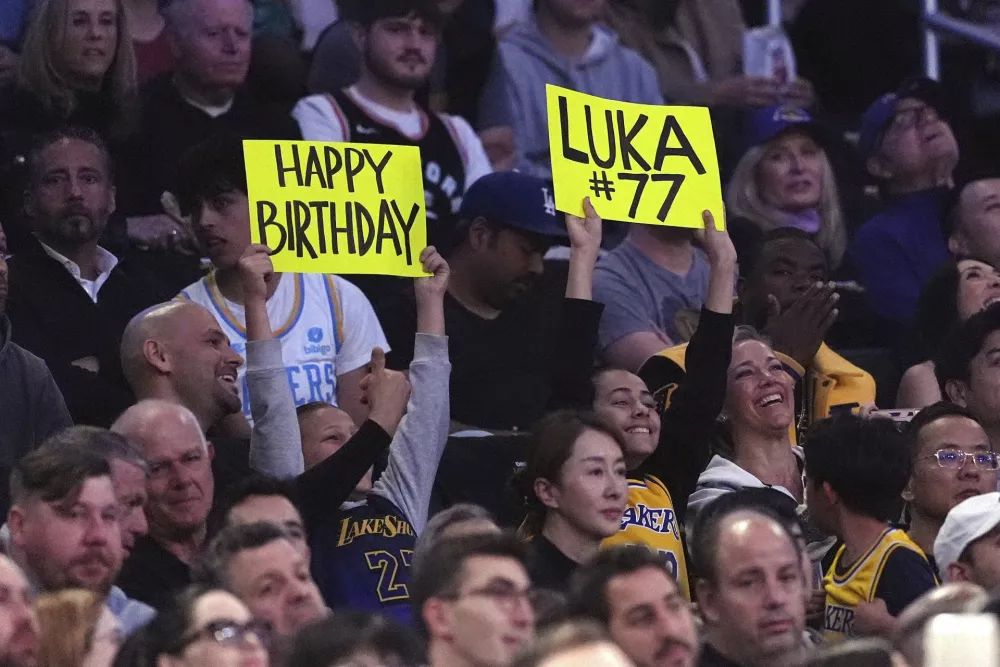 Fans hold up signs for Los Angeles Lakers guard Luka Doncic during the first half of an NBA basketball game against the Los Angeles Clippers, Friday, Feb. 28, 2025, in Los Angeles. (AP Photo/Mark J. Terrill)