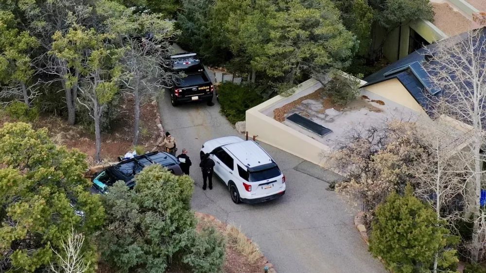 Law enforcement officials talk outside the home of actor Gene Hackman on Thursday, Feb. 27, 2025 in Santa Fe, New Mexico. Hackman, his wife Betsy Arakawa and their dog were found dead in the home a day earlier. (AP Photo/Roberto Rosales)