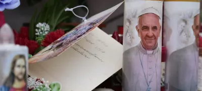 Candles with the pictures of Pope Francis are the laid under the statue of late Pope John Paul II outside Agostino Gemelli Polyclinic in Rome, Wednesday, Feb. 19, 2025, where the Pontiff is hospitalized since Friday, Feb. 14. (AP Photo/Gregorio Borgia)