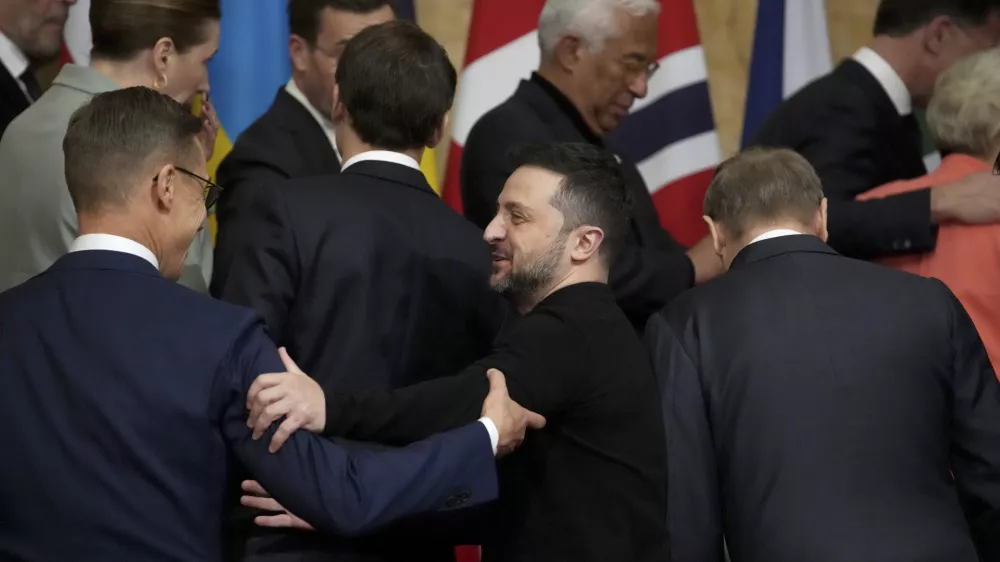 Ukraine's President Volodymyr Zelenskyy, center, speaks with Finland's President Alexander Stubb, left, during a group photo at a summit on Ukraine at Lancaster House in London, Sunday, March 2, 2025. (AP Photo/Christophe Ena, Pool)