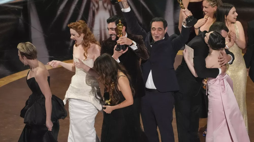 Daria Ekamasova, from left, Lindsey Normington, Samantha Quan, Vache Tovmasyan, Karren Karagulian, Alex Coco, and Mikey Madison accept the award for best picture for "Anora" during the Oscars on Sunday, March 2, 2025, at the Dolby Theatre in Los Angeles. (AP Photo/Chris Pizzello)