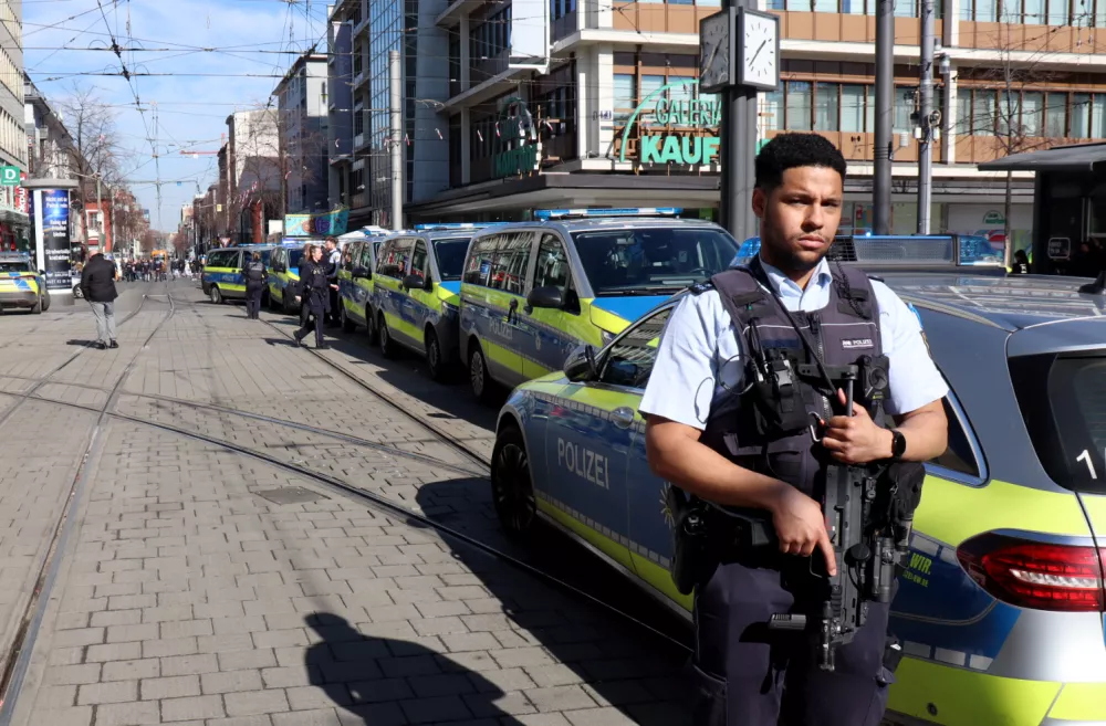 03 March 2025, Baden-Württemberg, Mannheim: A police officer secures a street in the city center during a large-scale police operation. Following an incident involving a car in Mannheim city center that left at least one person dead and several injured, the suspected driver has been arrested, according to police. According to the police, a vehicle had driven into a crowd of people. Photo: René Priebe/dpa