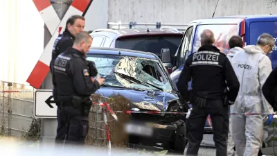 Police officers stand next to a damaged vehicle in the city center of Mannheim, Germany, Monday March 3, 2025, following an incident in which one person was killed and others injured when a car rammed into a crowd, German police said. (Boris Roessler/dpa via AP)