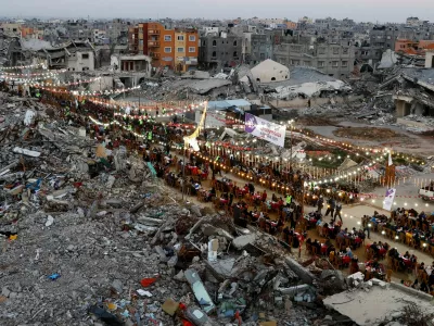 FILE PHOTO: Palestinians break their fast by eating the Iftar meals during the holy month of Ramadan, near the rubble of buildings, amid a ceasefire between Israel and Hamas, in Rafah, in the southern Gaza Strip, March 1, 2025. REUTERS/Hatem Khaled/File Photo