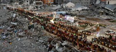 FILE PHOTO: Palestinians break their fast by eating the Iftar meals during the holy month of Ramadan, near the rubble of buildings, amid a ceasefire between Israel and Hamas, in Rafah, in the southern Gaza Strip, March 1, 2025. REUTERS/Hatem Khaled/File Photo