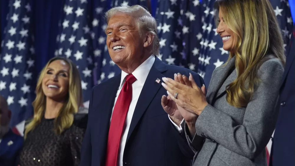 Republican presidential nominee former President Donald Trump stands on stage with former first lady Melania Trump, as Lara Trump watches, at an election night watch party at the Palm Beach Convention Center, Wednesday, Nov. 6, 2024, in West Palm Beach, Fla. (AP Photo/Evan Vucci)