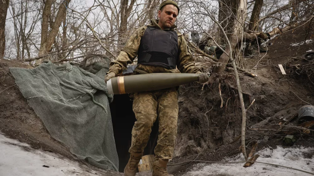 An Ukrainian serviceman carries a shell to fire a M777 howitzer towards Russian positions at the frontline near Donetsk, Ukraine, Sunday, March, 2, 2025. (AP Photo/Roman Chop)