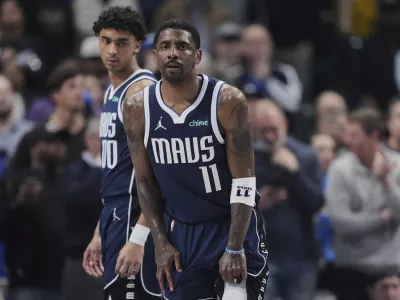 Dallas Mavericks' Kyrie Irving (11) and Max Christie, left, look on after Irving suffered an unknown injury in the first half of an NBA basketball game against the Sacramento Kings in Dallas, Monday, March 3, 2025. (AP Photo/Tony Gutierrez)