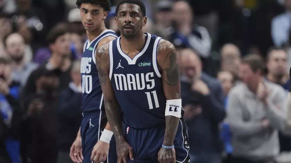 Dallas Mavericks' Kyrie Irving (11) and Max Christie, left, look on after Irving suffered an unknown injury in the first half of an NBA basketball game against the Sacramento Kings in Dallas, Monday, March 3, 2025. (AP Photo/Tony Gutierrez)