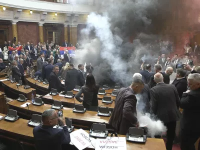 In this grab taken from video provided by RTS Serbia smoke bombs and flares are released in parliament, in Belgrade, Serbia, Tuesday, March 4, 2025. (RTS Serbia via AP)