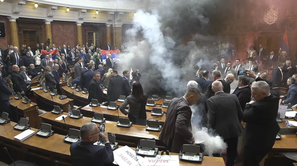 In this grab taken from video provided by RTS Serbia smoke bombs and flares are released in parliament, in Belgrade, Serbia, Tuesday, March 4, 2025. (RTS Serbia via AP)