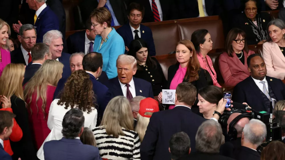 U.S. President Donald Trump attends a joint session of Congress as Rep. Melanie Stansbury (D-NM) holds a sign reading "This is not normal", in the House Chamber of the U.S. Capitol in Washington, D.C., U.S., March 4, 2025. REUTERS/Evelyn Hockstein