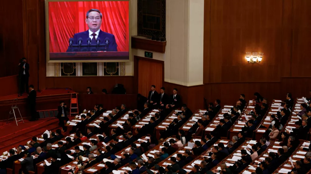 A screen shows Chinese Premier Li Qiang delivering a speech during the opening session of the National People's Congress (NPC) at the Great Hall of the People in Beijing, China, March 5, 2025. REUTERS/Tingshu Wang