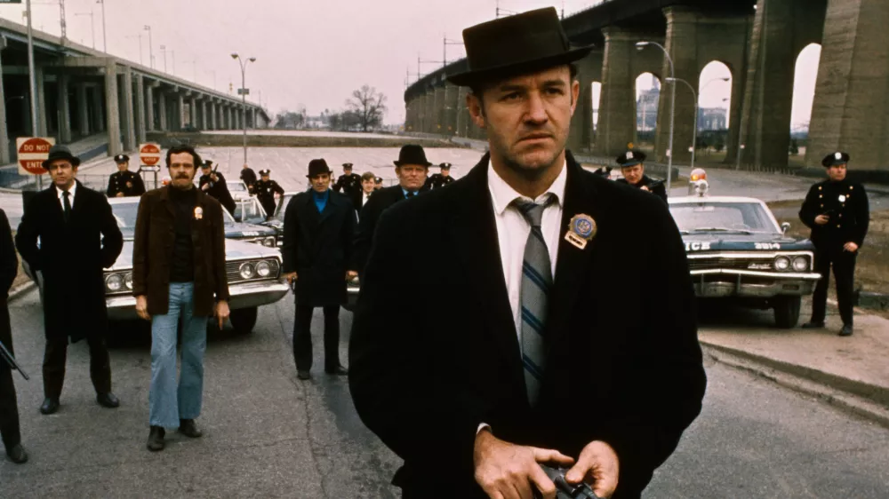 Policeman Gene Hackman is shown in this movie still walking toward the camera. He is holding a gun in his hands with policemen and police vehicles in the background. It was in this movie The French Connection that Gene Hackman won "Best Actor." The movie itself won "Best Picture." / Foto: Bettmann