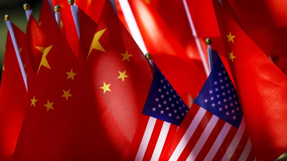 ﻿In this Sept. 16, 2018, photo, American flags are displayed together with Chinese flags on top of a trishaw in Beijing. The American Chamber of Commerce in China says Beijing will "dig its heels in" after U.S. tariff hikes and appealed for a negotiated end to their trade battle. The chamber on Tuesday, Sept. 18 warned a "downward spiral" appears certain after President Donald Trump approved a tariff hike on $200 billion of Chinese imports in a dispute over Beijing's technology policy. (AP Photo/Andy Wong)