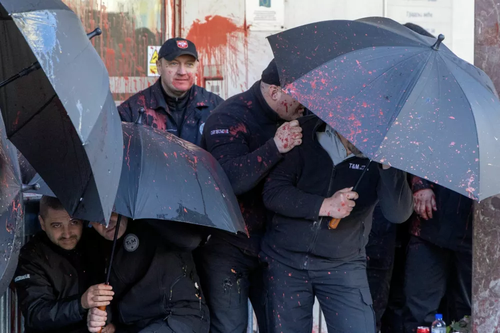 Belgrade City Hall security officials protect themselves as protestors throw eggs and red paint during the protest in Belgrade, Serbia, March 6, 2025. REUTERS/Djordje Kojadinovic   TPX IMAGES OF THE DAY