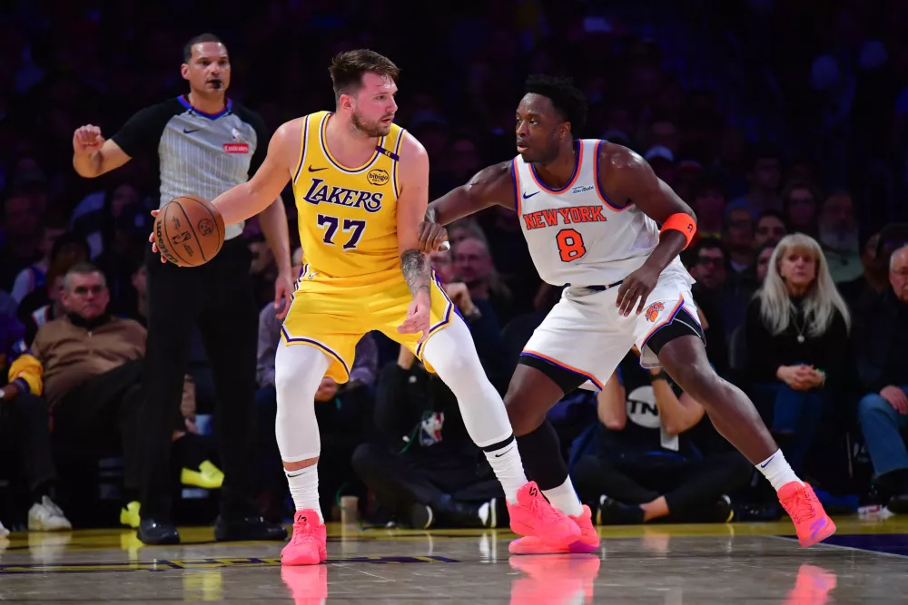 Mar 6, 2025; Los Angeles, California, USA; Los Angeles Lakers guard Luka Doncic (77) moves the ball against New York Knicks forward OG Anunoby (8) during the first half at Crypto.com Arena. Mandatory Credit: Gary A. Vasquez-Imagn Images