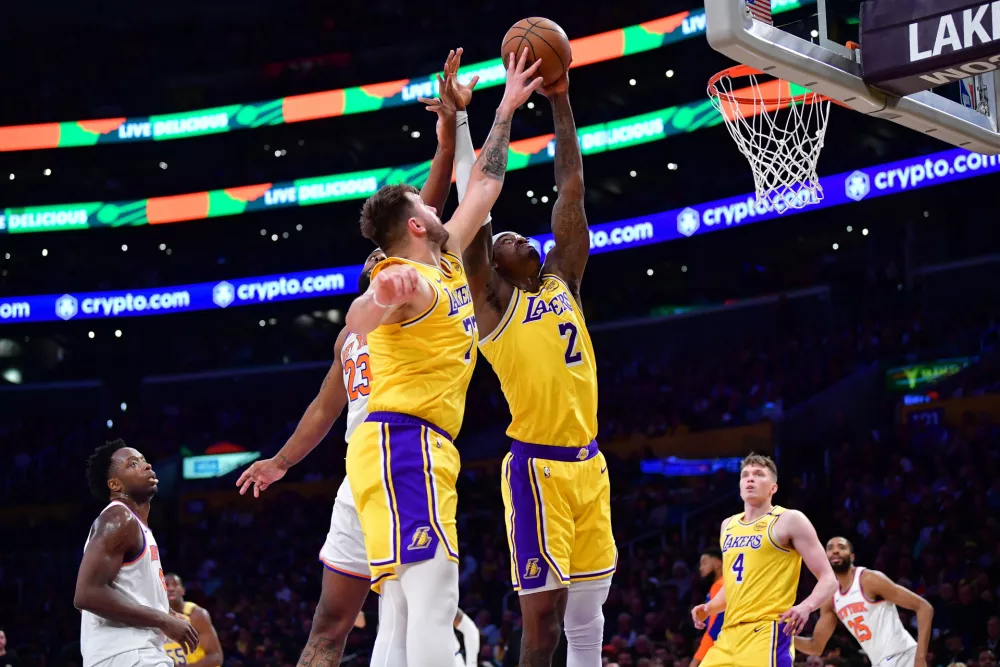 Mar 6, 2025; Los Angeles, California, USA; Los Angeles Lakers guard Luka Doncic (77) and forward Jarred Vanderbilt (2) play for the rebound against New York Knicks center Mitchell Robinson (23) during the first half at Crypto.com Arena. Mandatory Credit: Gary A. Vasquez-Imagn Images