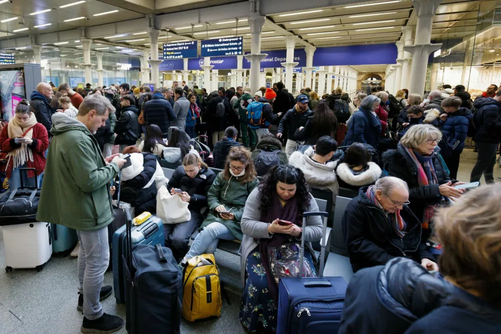 Passengers wait as people gather at the departure gates of the Eurostar terminal at St Pancras International Station after the services are cancelled due to a flooded tunnel, in London, Britain, December 30, 2023. REUTERS/Belinda Jiao