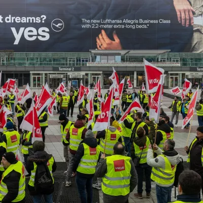 verdi Warnstreik am Flughafen München, 28.02.25 Streikende Gewerkschaftsmitglieder der Verdi versammeln sich vor Terminal 2 des Münchner Flughafens. Die Demonstranten tragen gelbe Warnwesten und schwenken rote Verdi-Fahnen. Im Hintergrund ist eine große Lufthansa-Werbung für die neue Business Class zu sehen. Der Warnstreik führt zu erheblichen Einschränkungen im Flughafenbetrieb, insbesondere bei der Abfertigung von Passagieren. Oberding Schwaig Bayern Deutschland *** Verdi warning strike at Munich Airport, 28 02 25 Striking Verdi union members gather in front of Terminal 2 at Munich Airport The demonstrators wear yellow high-visibility vests and wave red Verdi flags A large Lufthansa advertisement for the new Business Class can be se 20250228-286A0012-M4000,Image: 970247800, License: Rights-managed, Restrictions: imago is entitled to issue a simple usage license at the time of provision. Personality and trademark rights as well as copyright laws regarding art-works shown must be observed. Commercial use at your own risk., Model Release: no