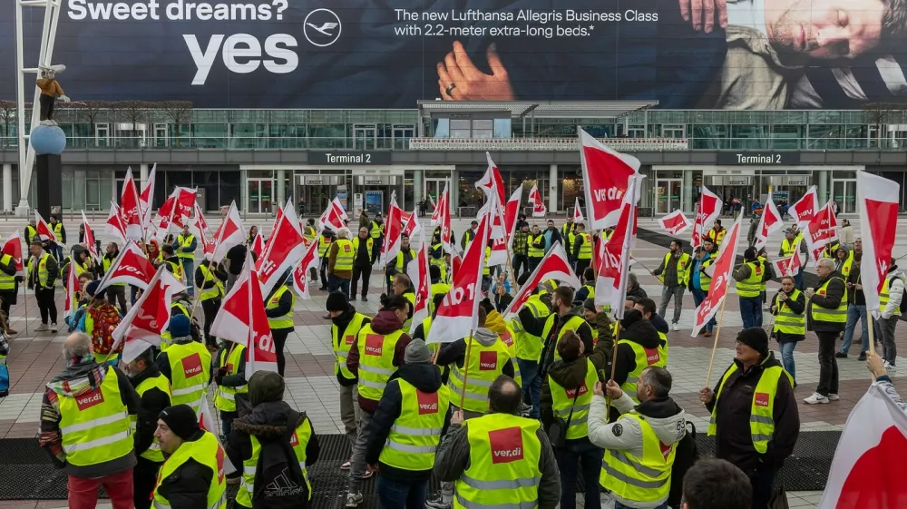 verdi Warnstreik am Flughafen München, 28.02.25 Streikende Gewerkschaftsmitglieder der Verdi versammeln sich vor Terminal 2 des Münchner Flughafens. Die Demonstranten tragen gelbe Warnwesten und schwenken rote Verdi-Fahnen. Im Hintergrund ist eine große Lufthansa-Werbung für die neue Business Class zu sehen. Der Warnstreik führt zu erheblichen Einschränkungen im Flughafenbetrieb, insbesondere bei der Abfertigung von Passagieren. Oberding Schwaig Bayern Deutschland *** Verdi warning strike at Munich Airport, 28 02 25 Striking Verdi union members gather in front of Terminal 2 at Munich Airport The demonstrators wear yellow high-visibility vests and wave red Verdi flags A large Lufthansa advertisement for the new Business Class can be se 20250228-286A0012-M4000,Image: 970247800, License: Rights-managed, Restrictions: imago is entitled to issue a simple usage license at the time of provision. Personality and trademark rights as well as copyright laws regarding art-works shown must be observed. Commercial use at your own risk., Model Release: no