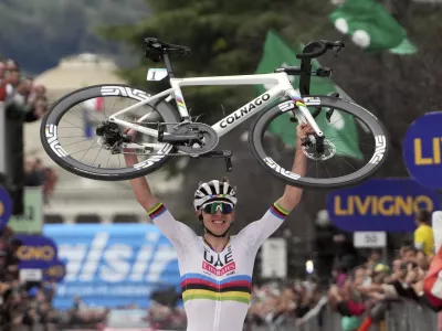 Reigning World Champion Slovenia's Tadej Pogacar holds up his bike as he celebrates winning Il Lombardia, Tour of Lombardy cycling race, in Como, Italy, Saturday, Oct. 12, 2024. (Gian Mattia D'Alberto/LaPresse via AP)