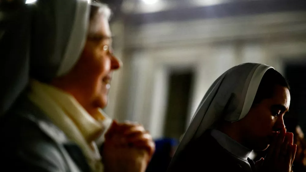 FILE PHOTO: Faithful listen to an audio message by Pope Francis at the Vatican, March 6, 2025. REUTERS/Yara Nardi/File Photo