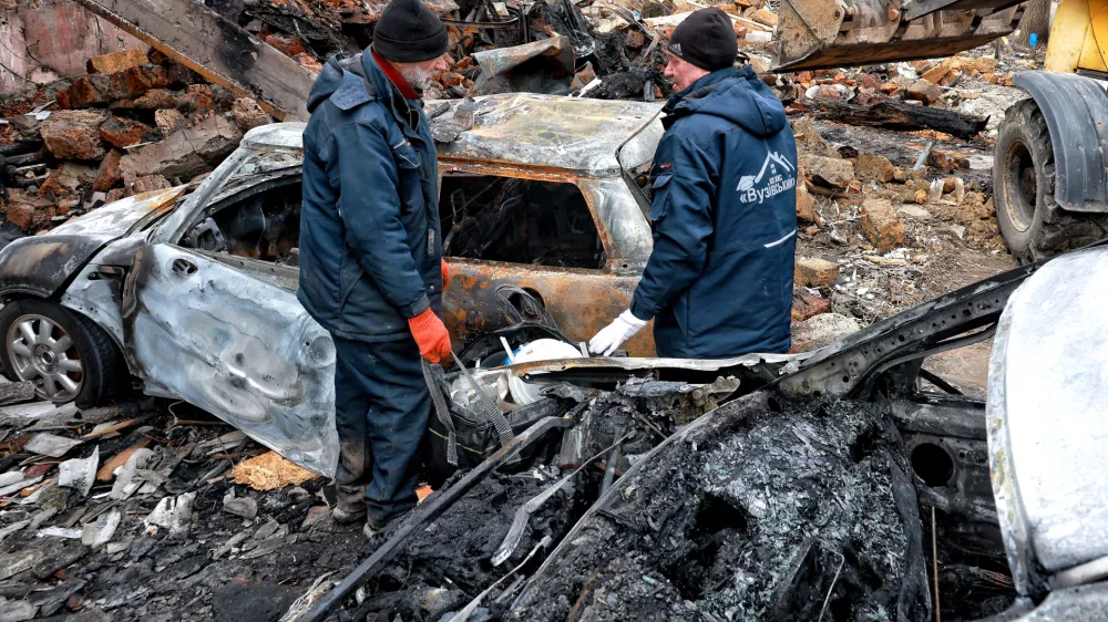 FILED - 04 March 2025, Ukraine, Odesa: Utility workers stand next to the cars burned down as a result of a Russian drone attack on Odesa. Photo: Nina Liashonok/Ukrinform/dpa