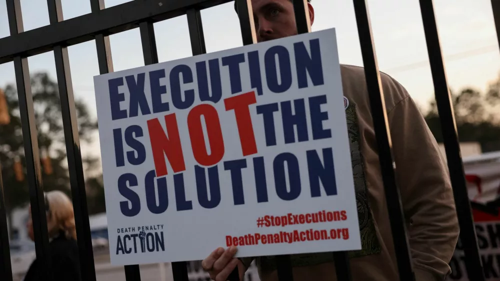 A demonstrator holds a sign outside the South Carolina Department of Corrections (SCDC), following the execution of death row inmate Brad Sigmon, 67, by firing squad method, at the Broad River Correctional Institution in Columbia, South Carolina, U.S., March 7, 2025. REUTERS/Shannon Stapleton