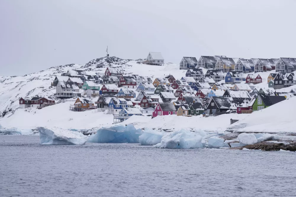 Coloured houses covered by snow are seen from the sea in Nuuk, Greenland, Thursday March 6, 2025. (AP Photo/Evgeniy Maloletka)