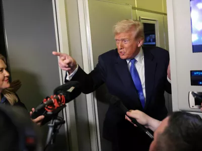 U.S. President Donald Trump speaks to reporters as White House Press Secretary Karoline Leavitt stands with him aboard Air Force One on his return to Washington, D.C., U.S., March 9, 2025. REUTERS/Kevin Lamarque