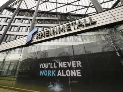 A screen reads "You'll never walk alone" at the headquarters of German weapon producer Rheinmetall ahead of the annual press conference in Duesseldorf, Germany, Wednesday, March 12, 2025. (AP Photo/Martin Meissner)