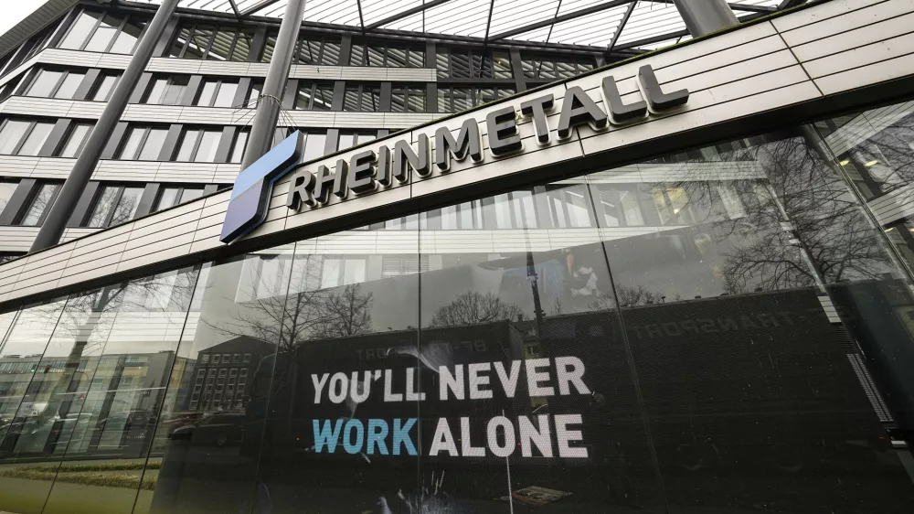 A screen reads "You'll never walk alone" at the headquarters of German weapon producer Rheinmetall ahead of the annual press conference in Duesseldorf, Germany, Wednesday, March 12, 2025. (AP Photo/Martin Meissner)