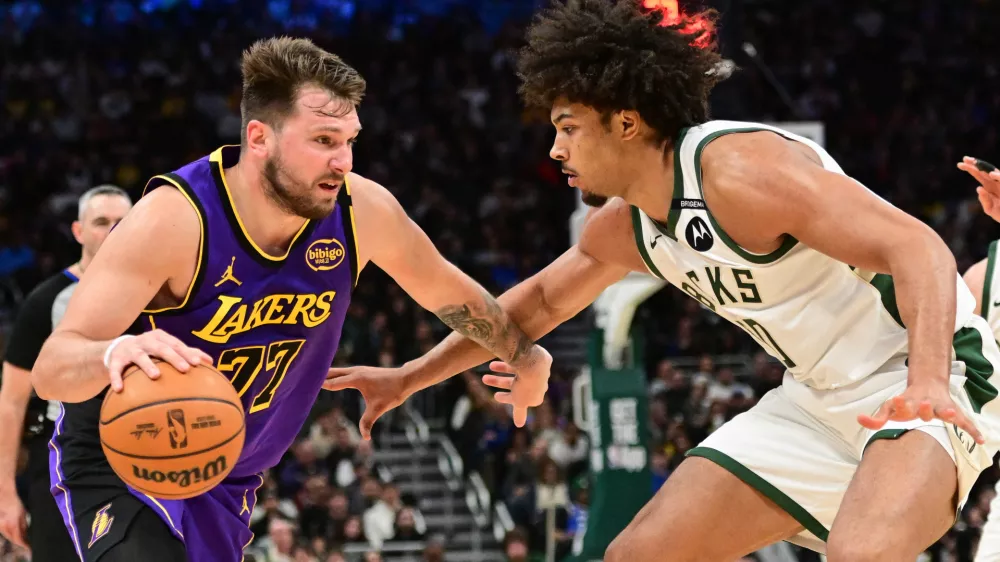 Mar 13, 2025; Milwaukee, Wisconsin, USA; Los Angeles Lakers guard Luka Doncic (77) drives to the basket against Milwaukee Bucks center Jericho Sims (00) in the fourth quarter at Fiserv Forum. Mandatory Credit: Benny Sieu-Imagn Images