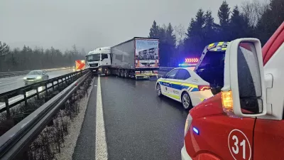 Kabina tovornjaka se je zagozdila med zaščitno ograjo in lastno prikolico.