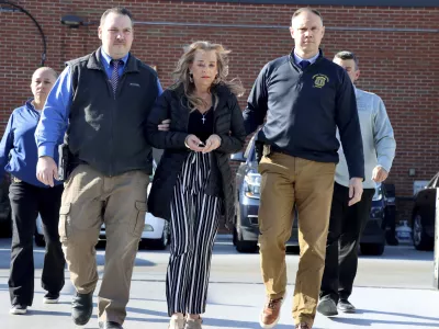 This photo provided by the Waterbury Police Department shows Kimberly Sullivan being taken into custody who was charged Wednesday, March 12, 2025, with kidnapping and cruelty for allegedly holding her 32-year-old stepson captive for more than 20 years. (Waterbury Police Department via AP)