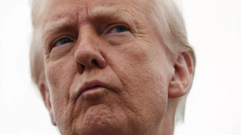 U.S. President Donald Trump takes a question from a reporter before boarding Air Force One as he departs from Joint Base Andrews in Maryland, D.C., U.S., March 14, 2025. REUTERS/Kevin Lamarque