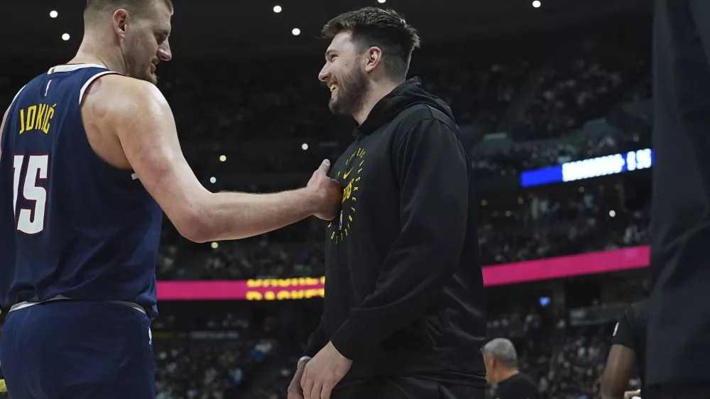 Denver Nuggets center Nikola Jokic, left, greets Los Angeles Lakers guard Luka Doncic, right, in the first half of an NBA basketball game Friday, March 14, 2025, in Denver. (AP Photo/David Zalubowski)