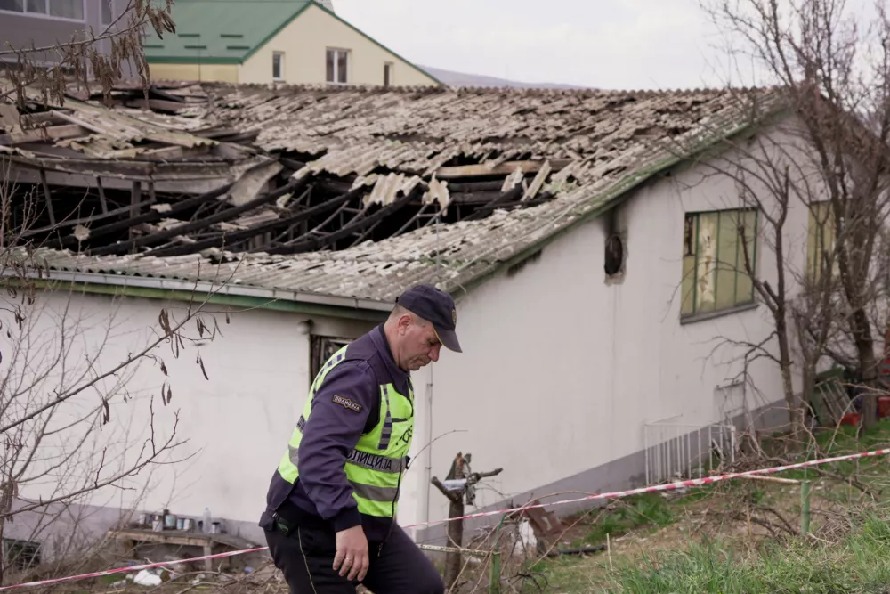 A police officer walks next to the damaged Pulse nightclub, following a fire that resulted in dozens of deaths in the town of Kocani, North Macedonia, March 17, 2025. REUTERS/Fedja Grulovic