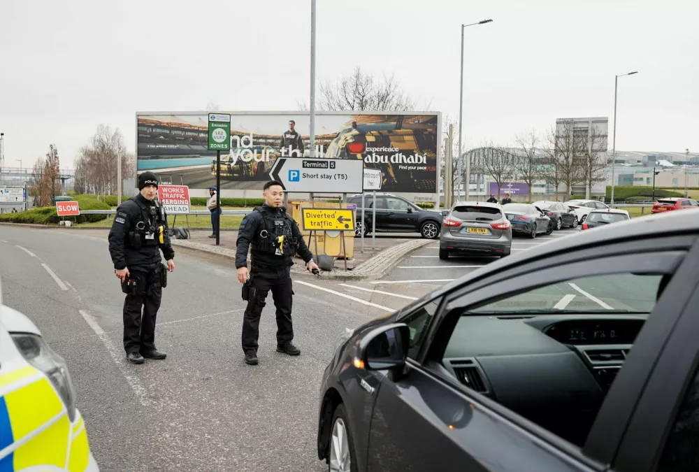 Members of the police stand near traffic outside Terminal 5 at the Heathrow International Airport after a fire at a nearby electrical substation wiped out power at the airport, near London, Britain, March 21, 2025. REUTERS/Carlos Jasso