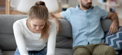 Unhappy young millennial married couple sitting on couch in living room after quarrel fight. Angry husband frustrated offended wife at home. Break up, divorce and misunderstanding in relations concept / Foto: Fizkes