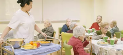 Female cook entering with food to the dining room of geriatric / Foto: Ramon Ivan Moreno Prieto